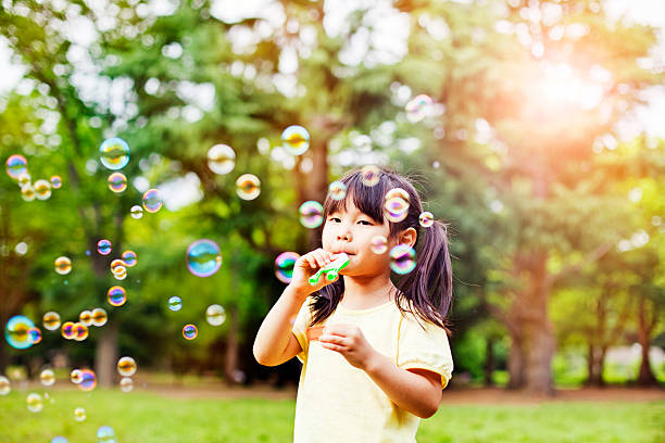 istock Little girl blowing soap bubbles 477815522