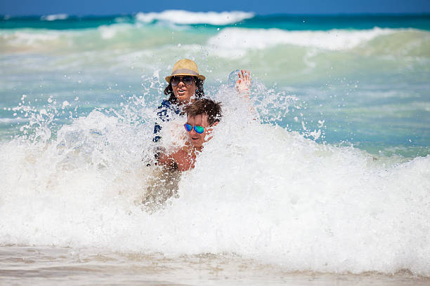 istock Young couple have a fun in the oceans waves 477816068
