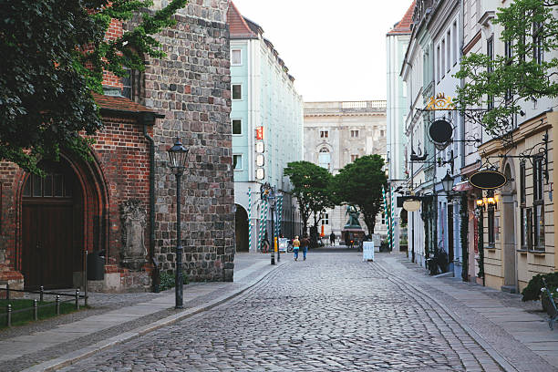 Cobblestone paved streets of Berlin's old town near Mitte city centre and the Alexanderplatz. Old brick walled buildings of the Medieval architecture can be seen and old town pubs as well. Down the street is the exit to the river Spree.