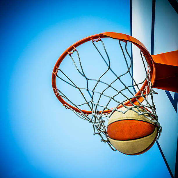 istock Basketball hitting in hoop with net 477820925