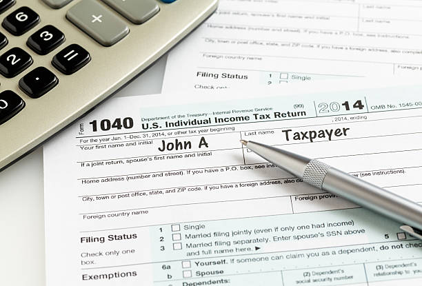 istock Pen and calculator on 2014 form 1040 477828388
