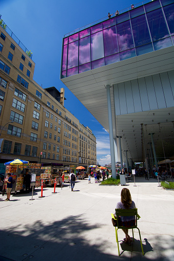 New York, USA - June 17, 2015: Lady sitting in front of Whitney museum, High Line Manhattan on a sunny day