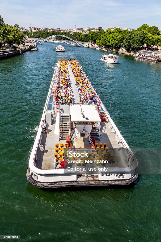 people enjoy the boat trip on River Seine in Paris Paris, France - June 13, 2015: people enjoy the boat trip on River Seine in Paris, France.  Some 3.5 million passengers per year discover  Paris by a Seine boat trip. 2015 Stock Photo
