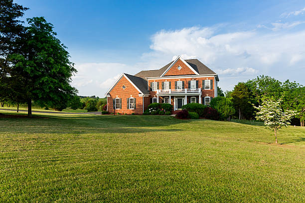 Front elevation large single family home Front of home and garage of large single family modern US house with landscaped gardens and lawn on a warm sunny summers day mansion photos stock pictures, royalty-free photos & images