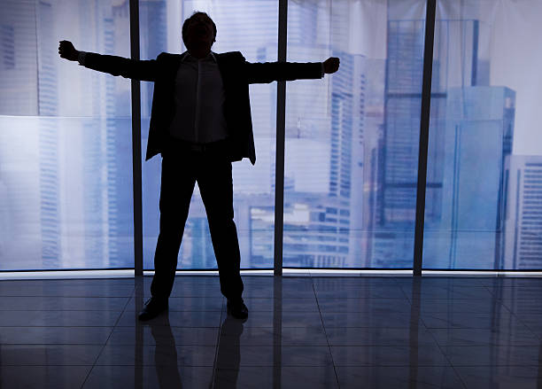 istock Businessman Standing Arms Outstretched By Office Window 477832990
