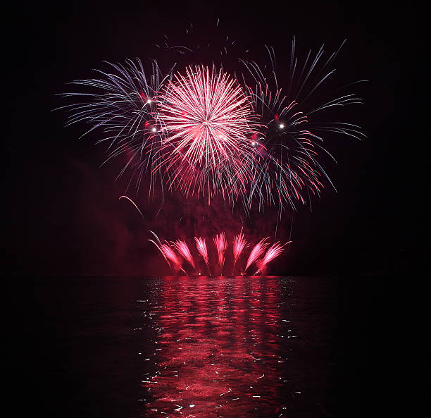kolorowe pokaz sztucznych ogni z refleksji nad jeziorem. - happy new year zdjęcia i obrazy z banku zdjęć