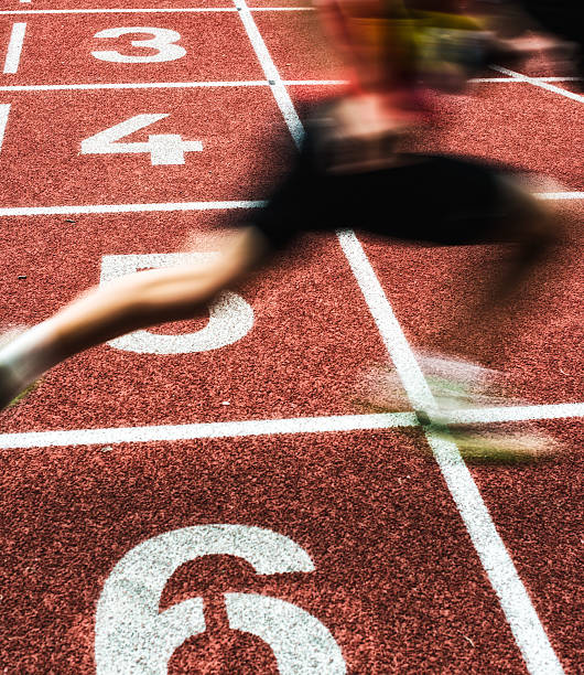 cruzar la línea de meta como ganador - pista de atletismo de tartán fotografías e imágenes de stock