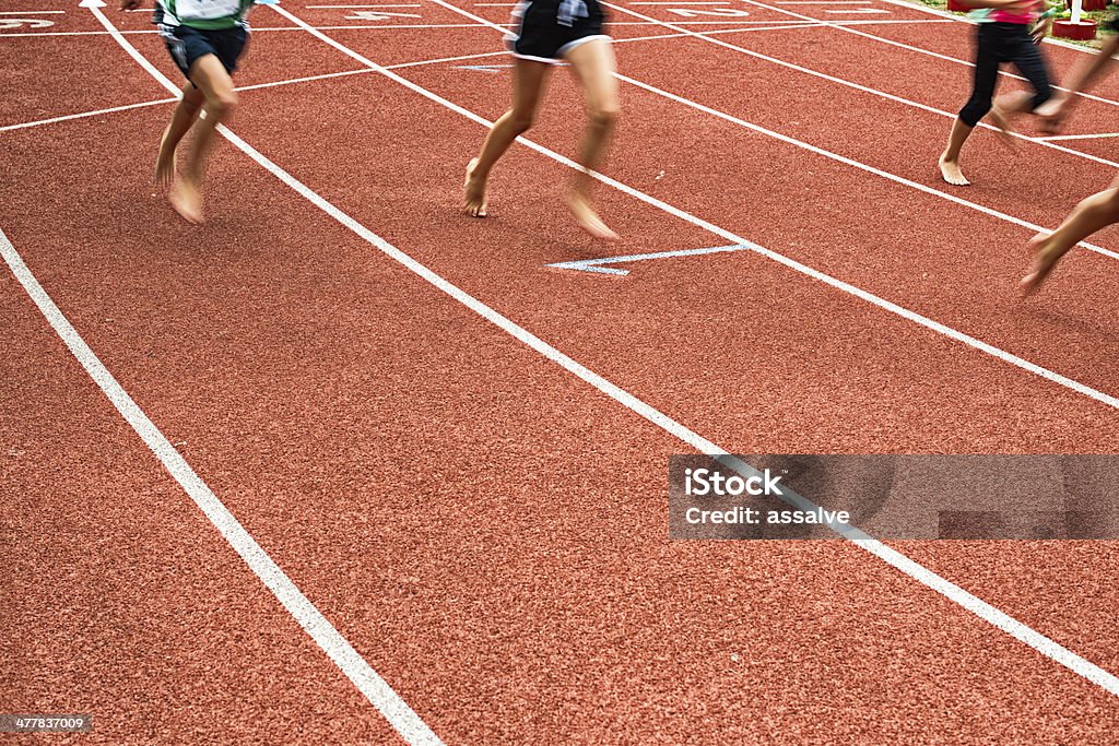 Niños corriendo a pies descalzos en pista tartan - Foto de stock de Niño libre de derechos