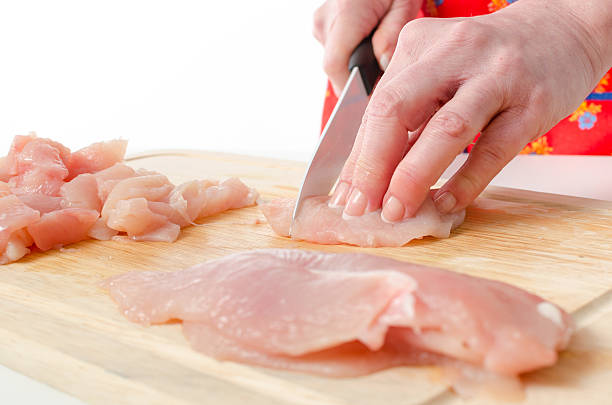istock Hands of woman cutting meat 477841506