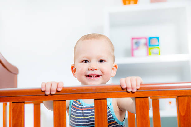 istock Baby boy standing in crib. 477842561
