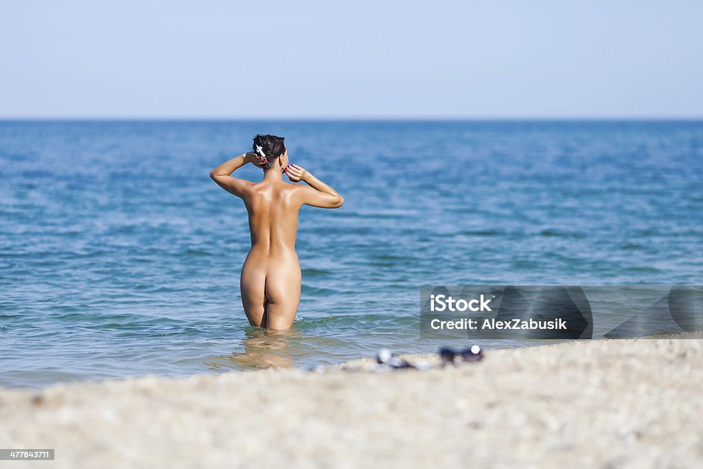 Girl at the sea Girl at the sea. Naked young woman going into the sea Naked Stock Photo