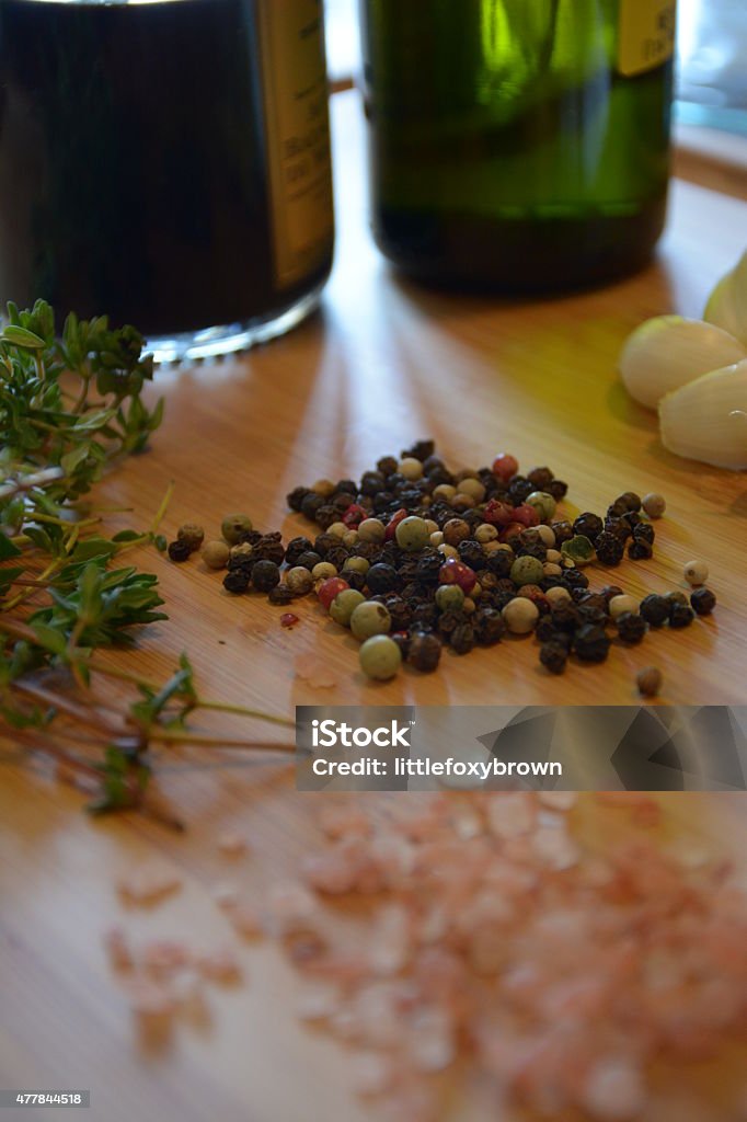 oil, vinegar, salt, pepper, garlic, and thyme bottle of olive oil, bottle of balsamic vinegar, garlic, thyme, salt, and peppercorns on a wood cutting board Thyme Stock Photo