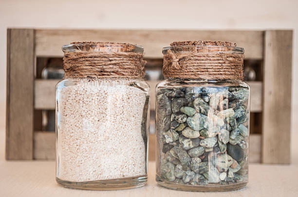 small glass jars with sand and stones from the beach