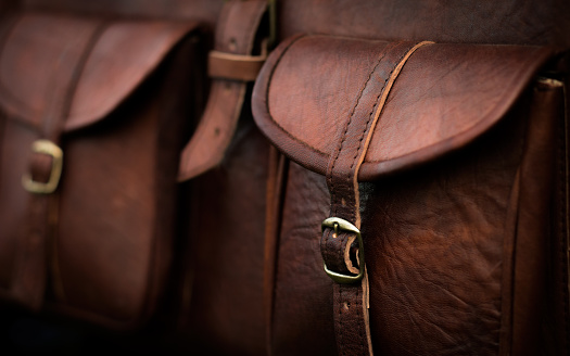 Close up of side pocket on a generic brown leather bag with a rustic design and fine stitching.