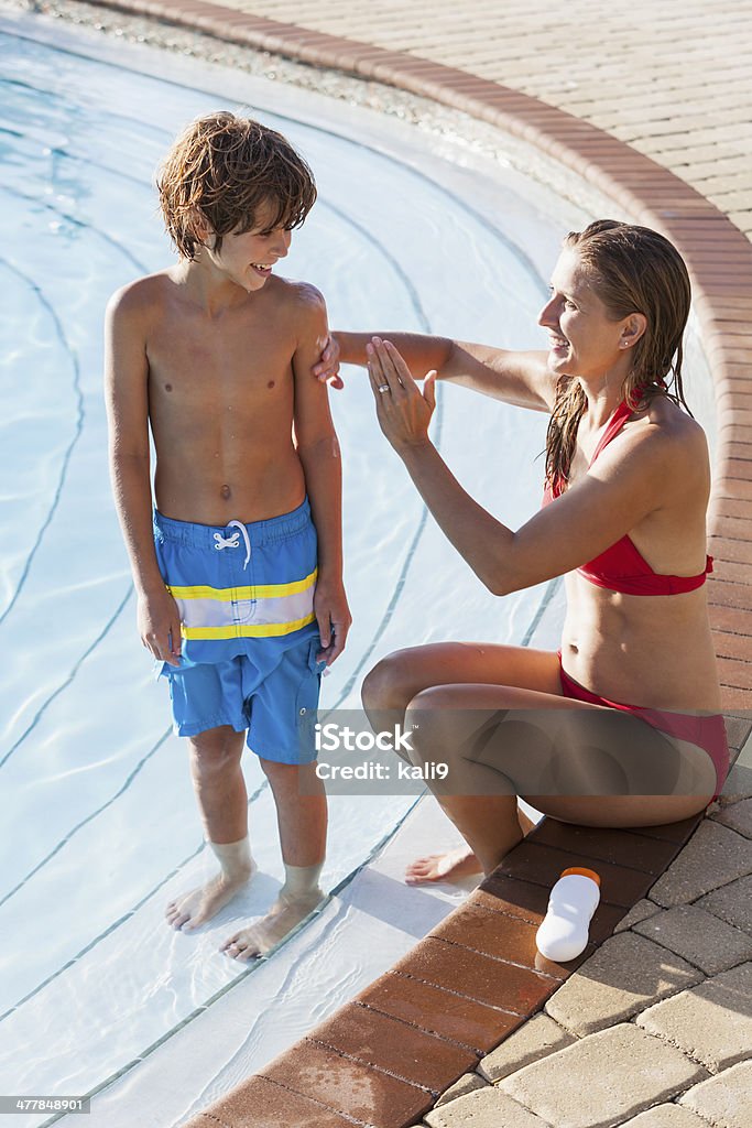 Mère et fils au bord de la piscine avec de la crème solaire - Photo de 30-34 ans libre de droits