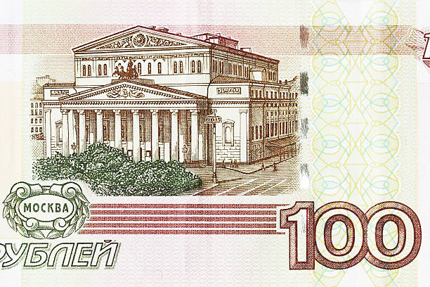 Reverse side of 100 ruble denomination Russian paper money printed in 1997 - the current currency of the Russian Federation. The image is of the facade of the Bolshoi Theater in Moscow.  The obverse side carries an image of the Quadriga statue - a four horse chariot - in front of the Bolshoi Theater.  Printed in Slavic language, the currency is minted in Moscow and St. Petersburg on high quality light pink cotton paper with multi-colored security fibers chaotically embedded throughout, plus watermarks in the right and left coupon fields. There are approximately 30 rubles to the U.S. dollar.