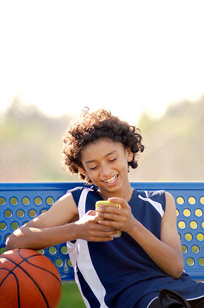 African American Boy reading a mobile tablet in the park stock photo