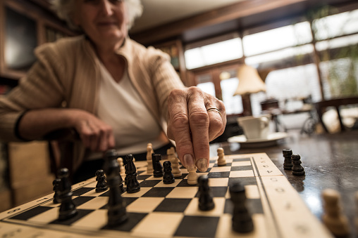 Close up of unrecognizable senior woman playing chess.