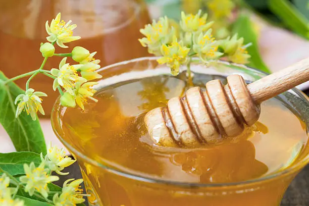 Bowl of fresh and delicious honey with linden flowers