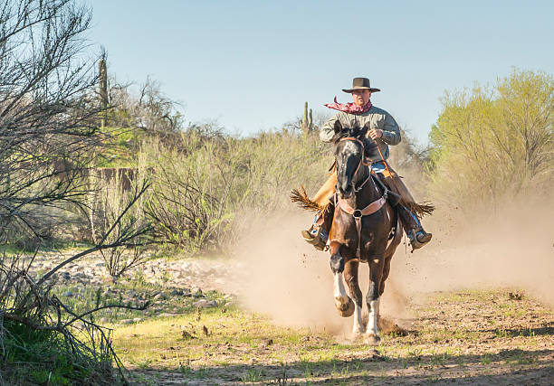 istock Cowboy riding horse straight 477858501