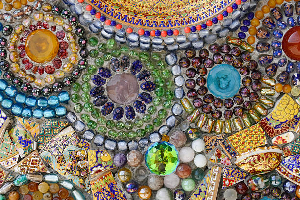 the art design of the colorful broken dish, bead and stone decorating on temple wall for abstract background