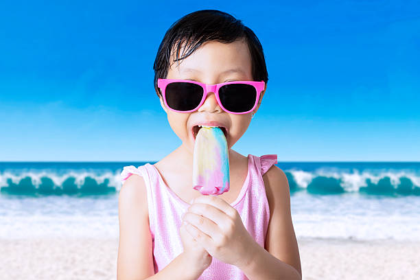 istock Female child eats ice cream at shore 477859200
