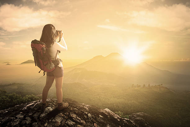 Female backpacker taking photo at mountain