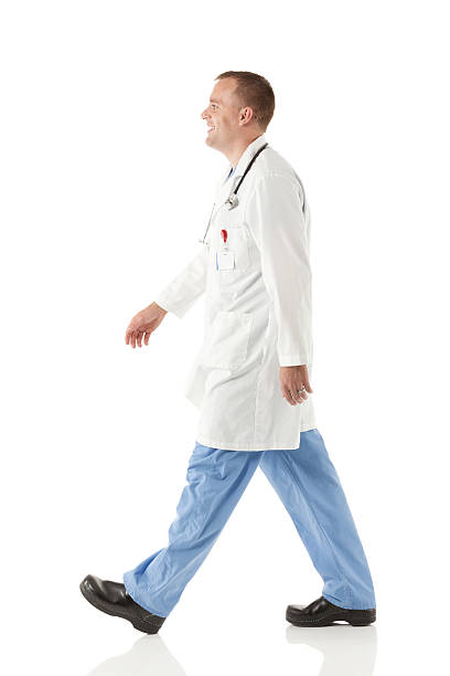 istock Happy male doctor walking 477860691