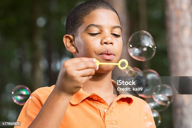 Foto de Menino Soprando Bolhas De Sabão e mais fotos de stock de Origem Africana - Origem Africana, Afro-americano, Bolha - Estrutura física