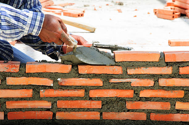 konstruktion mason arbeiter maurer ziegel mit trowe installieren - mason brick bricklayer installing stock-fotos und bilder