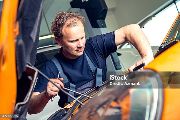 Homem Mecânico Peering No Compartimento Do Motor De Carro - Fotografias de stock e mais imagens de Adulto