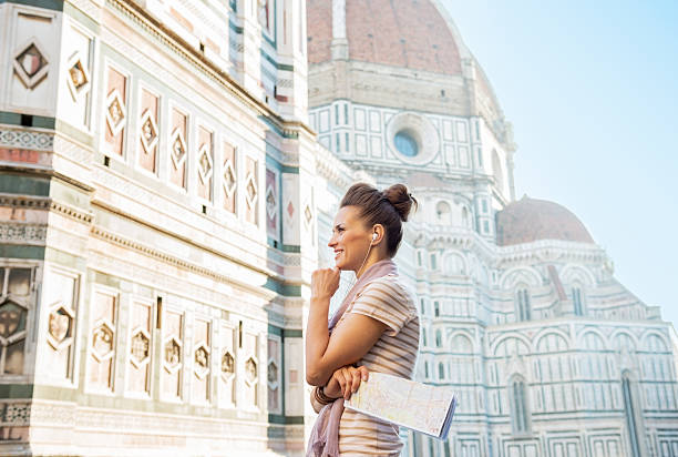 istock Happy young woman with audio guide in florence 477867352