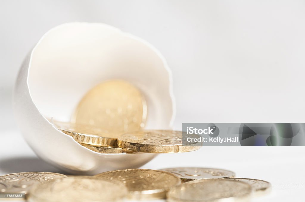 Monedas de oro salen de un huevo de carcasa - Foto de stock de Actividades bancarias libre de derechos