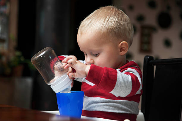 istock baby boy playing with bottle and mug indoor 477867975