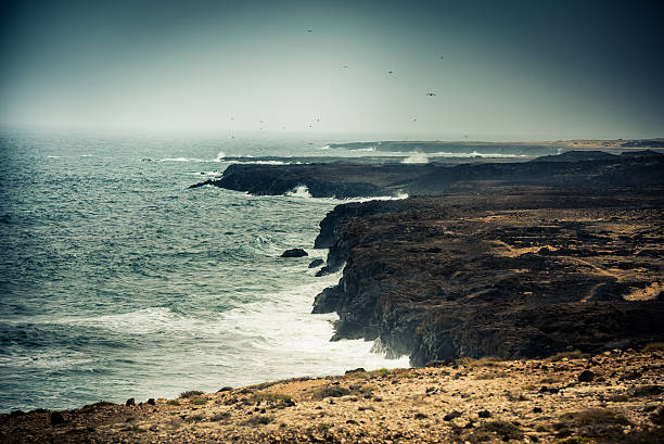 istock rocks meet seawaves 477871566