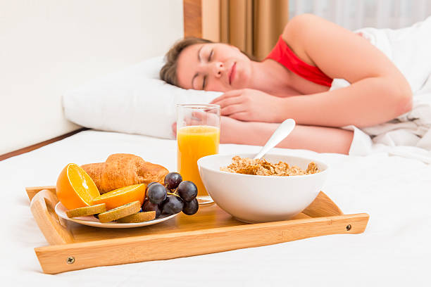 istock sleeping woman and a tray with breakfast 477872906