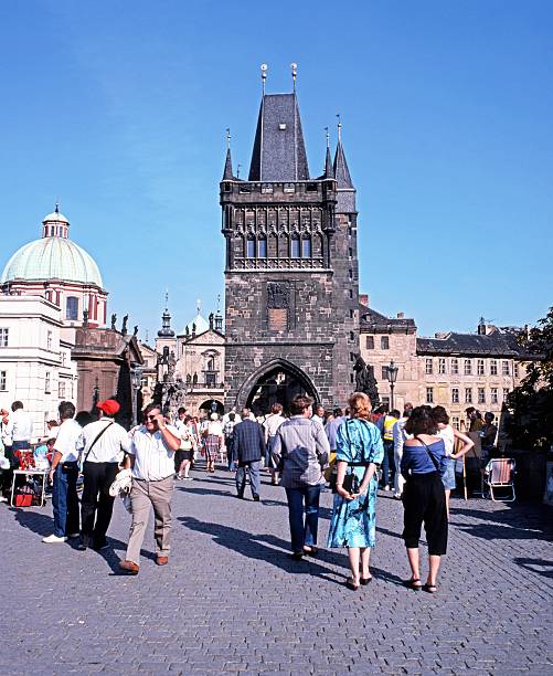 Old Town Bridge Tower, Prague. Prague, Czech Republic - August 25, 1990: Tourists walking across Charles Bridge towards the Old Town Bridge Tower, Prague, Czech Republic, Central Europe. old town bridge tower stock pictures, royalty-free photos & images