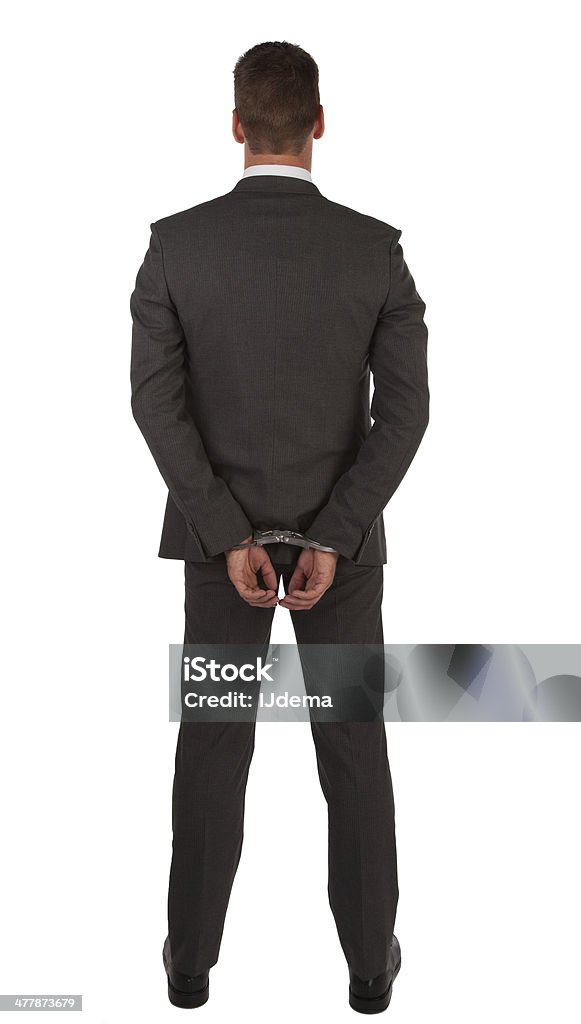 Hombre de negocios en traje y un pie atado al suelo - Foto de stock de Esposas - Dispositivo de seguridad libre de derechos