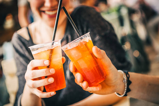 toasting with aperitif at the ourdoor cafe - wegwerpbeker stockfoto's en -beelden