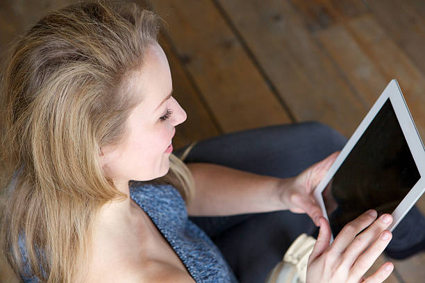 istock Woman holding computer tablet at home 477877957