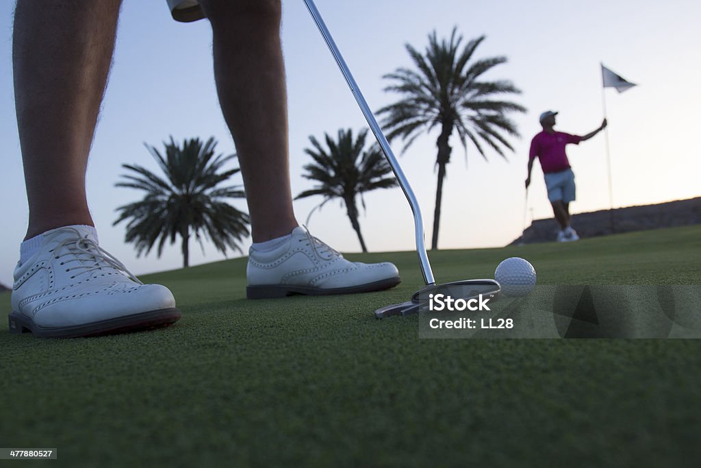 Uomo giocando a Golf con un amico con bandiera In Background - Foto stock royalty-free di Mazza da golf