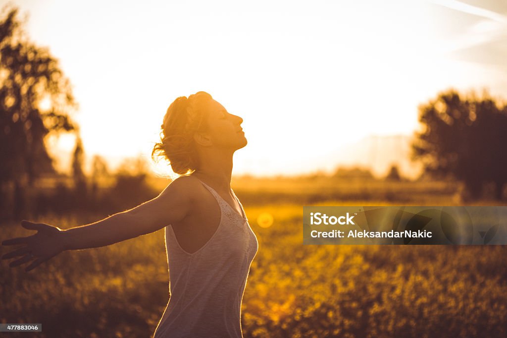 Deep breath Photo of young woman in nature with arms outstretched Gold Colored Stock Photo