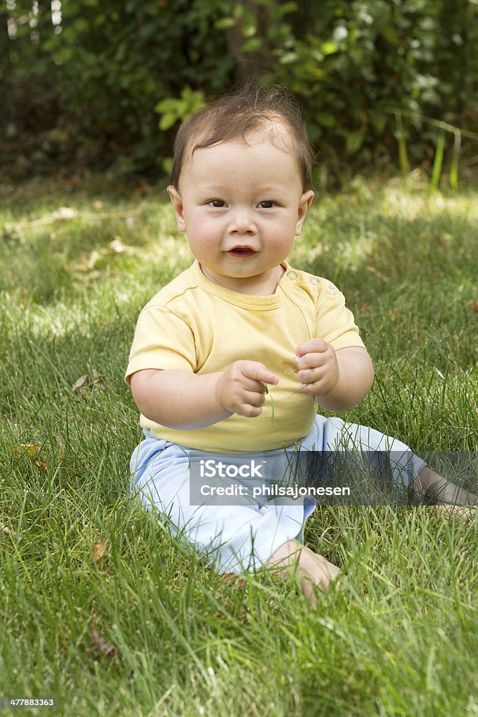 幸せな赤ちゃんの芝生に座る - カメ�ラ目線のロイヤリティフリーストックフォト