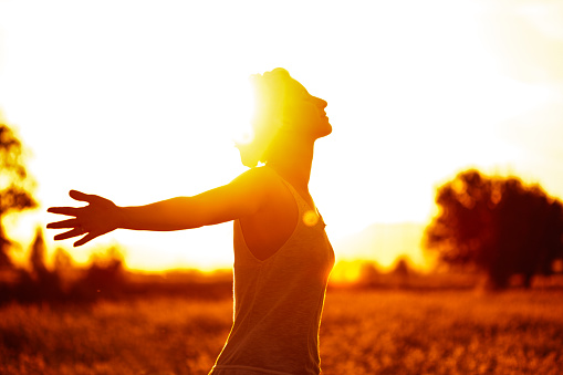 Photo of young woman in nature with arms outstretched