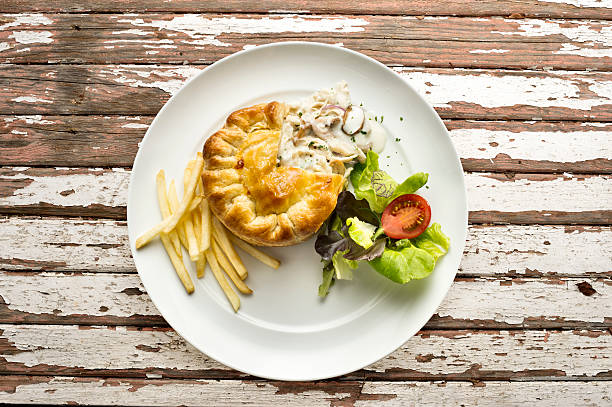 istock Chicken pie and fries on old wood background 477884819