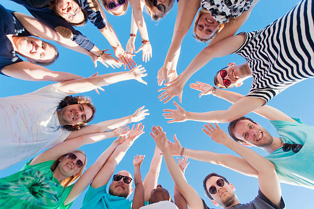 istock Young people raising hands and looking at camera 477884980