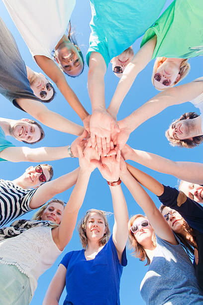 istock Young people holding hands together looking at camera 477885064