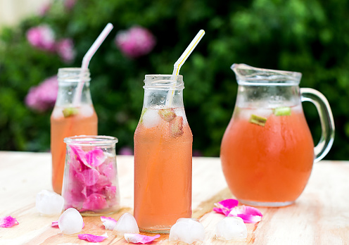 Rhubarb hibiscus drink iced tea with rose petals in the garden