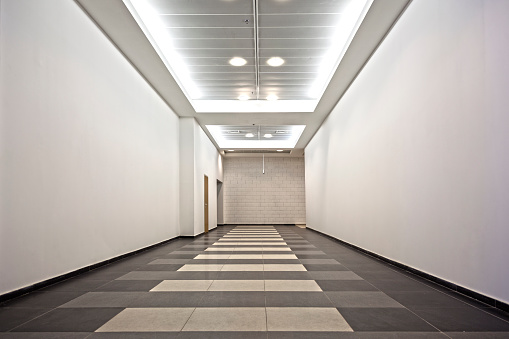 Empty corridor with white walls and deadlock at the end