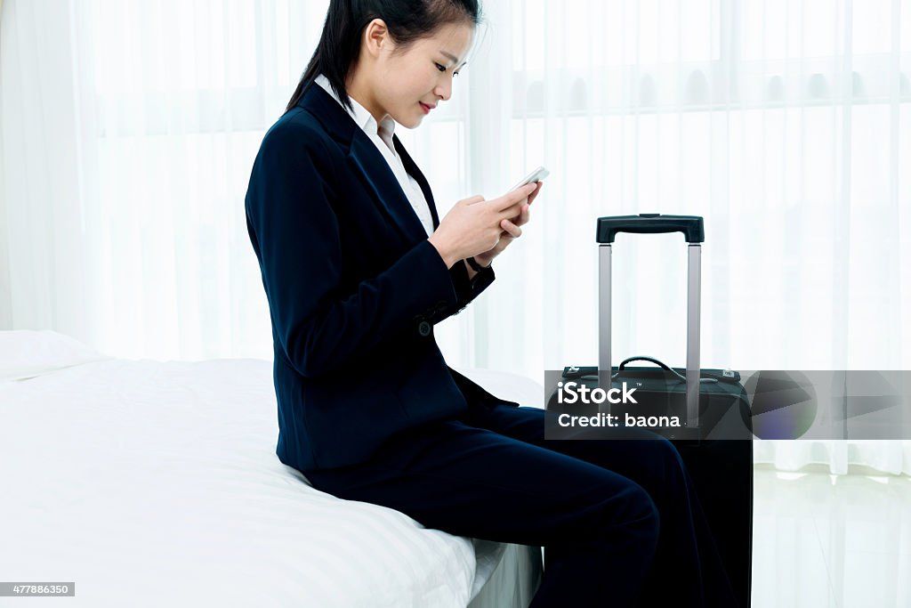 businesswoman texting message at hotel room Beautiful asian businesswoman texting message at hotel room 2015 Stock Photo